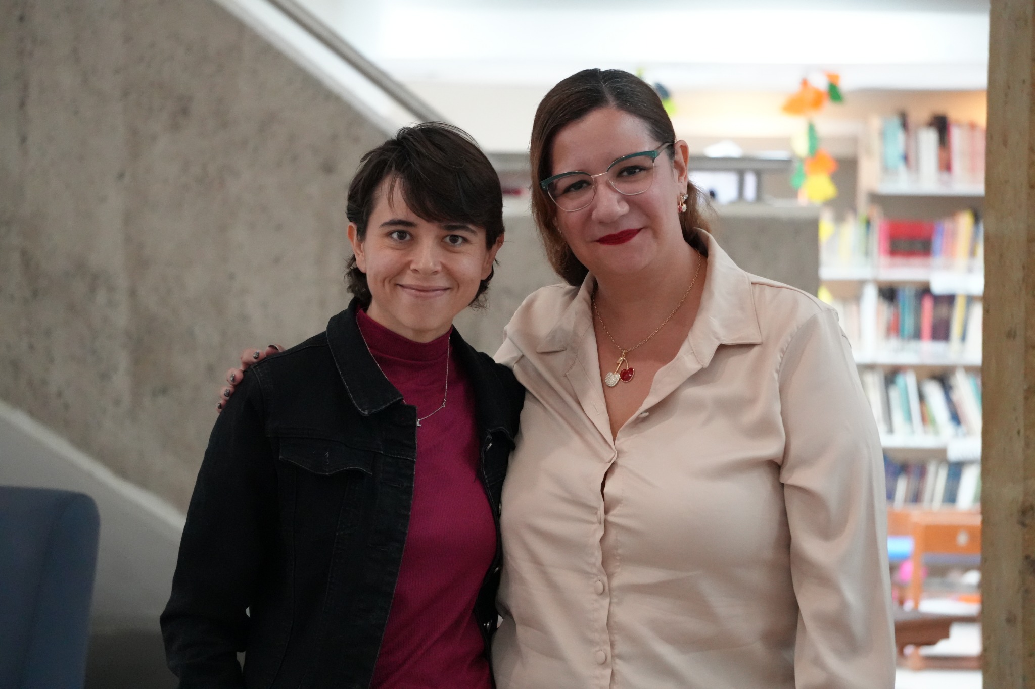 Leyla Karina Espinosa Yada con una participante en la biblioteca.