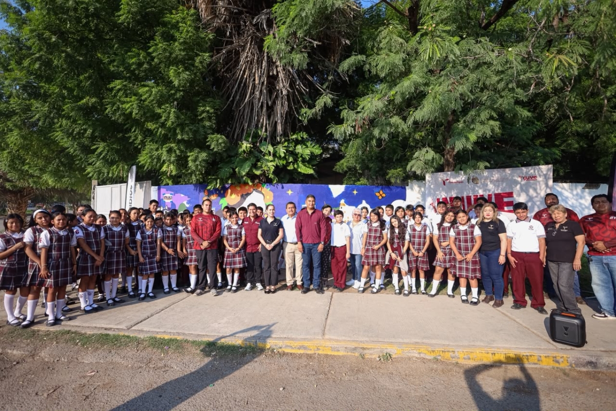 Fotografía oficial completa de participantes frente al mural en la Técnica 6.